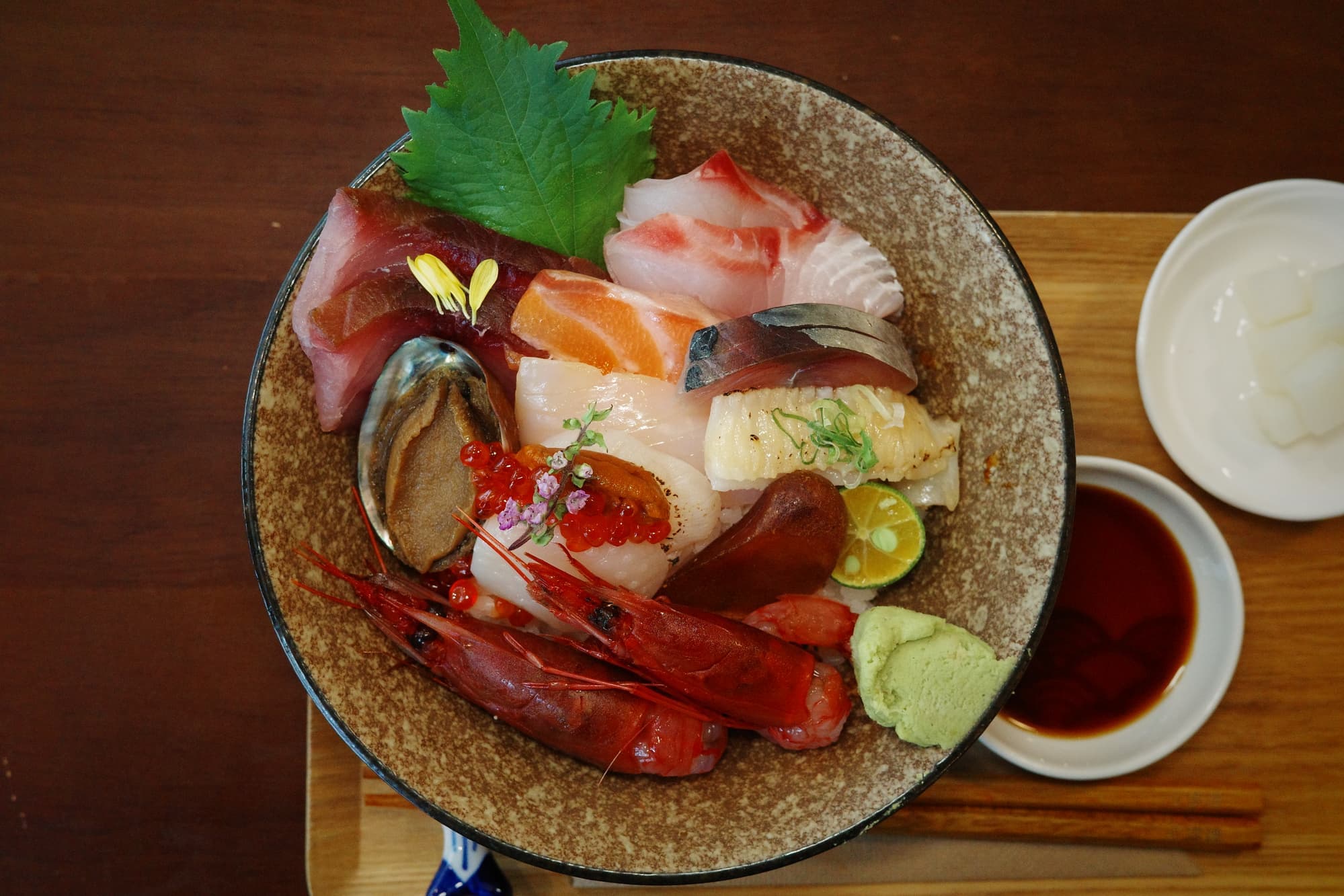 勉強中豪華海鮮丼，盛裝時令生魚片、胭脂蝦、章魚、鮑魚與干貝海膽，擺盤精緻，色澤鮮亮。